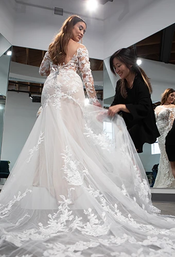 Bridal stylist helping a bride customize train