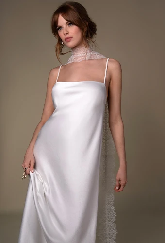 Bride wearing simple satin wedding dress with straight across neckline and thin spaghetti straps