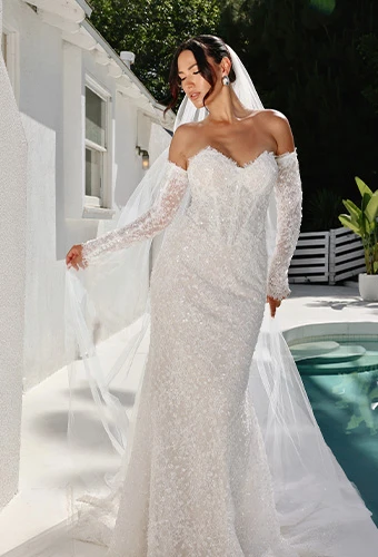 Bride wearing strapless lace column wedding dress with optional long sleeves