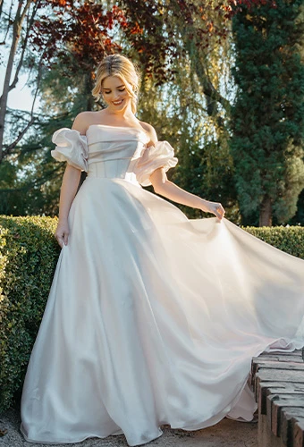 Bride wearing strapless ballgown wedding dress with detachable puff sleeves