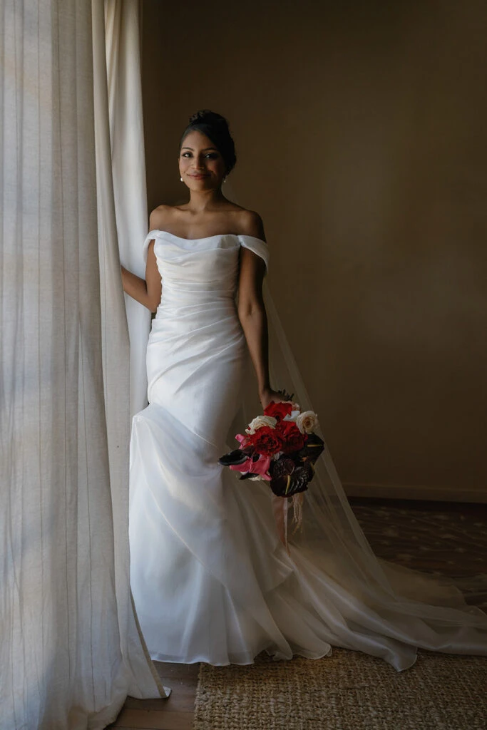 True bride Anna posing in her wedding gown with a bouquet of flowers