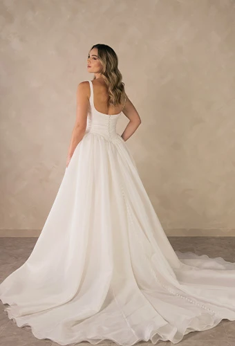 Bride wearing square neck a-line wedding dress with draped bodice and thin shoulder straps
