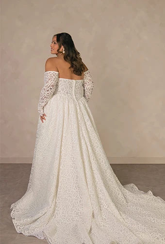 Plus size bride wearing lace strapless wedding dress with detachable sleeves