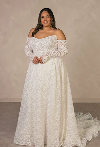 Plus size bride wearing lace strapless wedding dress with detachable sleeves