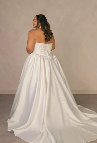 Plus size bride wearing minimalist strapless ballgown wedding dress with a basque waist