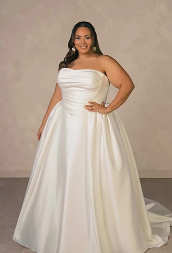 Plus size bride wearing minimalist strapless ballgown wedding dress with a basque waist