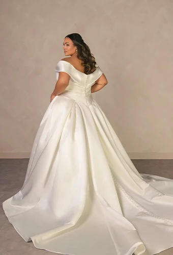 Plus size bride wearing satin ballgown wedding dress with off-the-shoulder straps