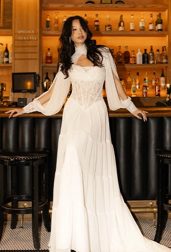 Bride wearing boho wedding dress with lace corset and sheet sleeves