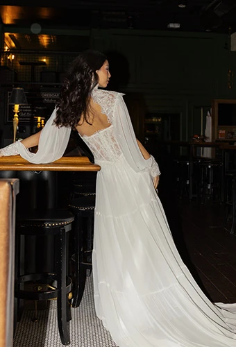 Bride wearing boho wedding dress with lace corset and sheet sleeves