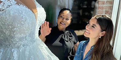 bride and bridal stylist looking at a mannequin of a ballgown wedding dress