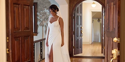 bride in a mansion wearing a simple white column wedding dress with side slit