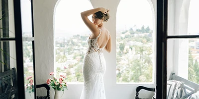 bride standing holding her hair up in the doorway