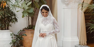 bride wearing a lace long sleeve wedding dress with high neck and veil
