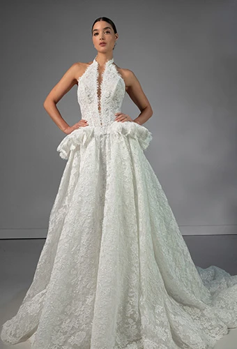 Bride wearing lace halter wedding dress with high neckline and peplum waist