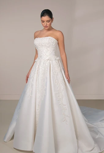 Bride wearing strapless ballgown wedding dress with straight across neckline and waist detail