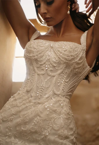 Bride wearing beaded lace wedding dress with square neckline and straps