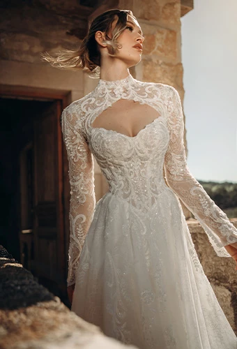 Bride wearing sparkling lace wedding dress with high neckline and long sleeves