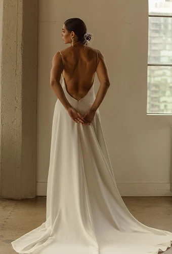 Bride wearing simple boho wedding dress with open back and thin spaghetti straps