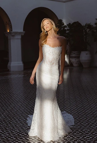 Bride wearing strapless lace fit-and-flare wedding dress with corset bodice.