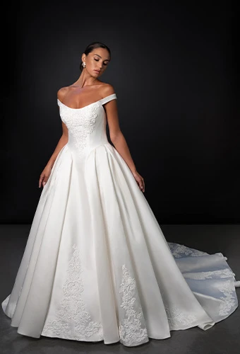 Bride wearing off-the-shoulder lace ballgown wedding dress with corset back.