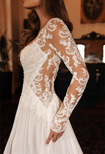 Bride wearing chiffon a-line wedding dress with illusion lace sleeves and lace side cutouts