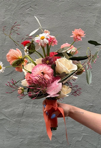 Spring floral bridal bouquet with ranunculus, lily of the valley and anemones.