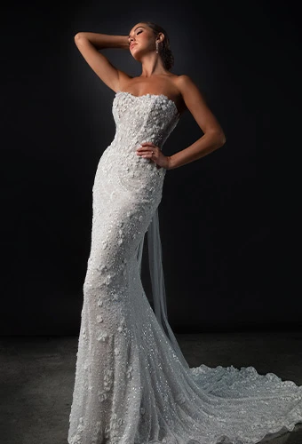 Bride wearing strapless fit-and-flare wedding dress with 3D floral lace, beading detail, and lace tulle train