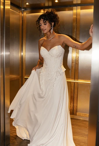 Bride wearing strapless boho wedding dress with sweetheart neckline and lace details