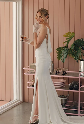 Bride wearing crepe sheath wedding dress with sweetheart neckline and high leg slit