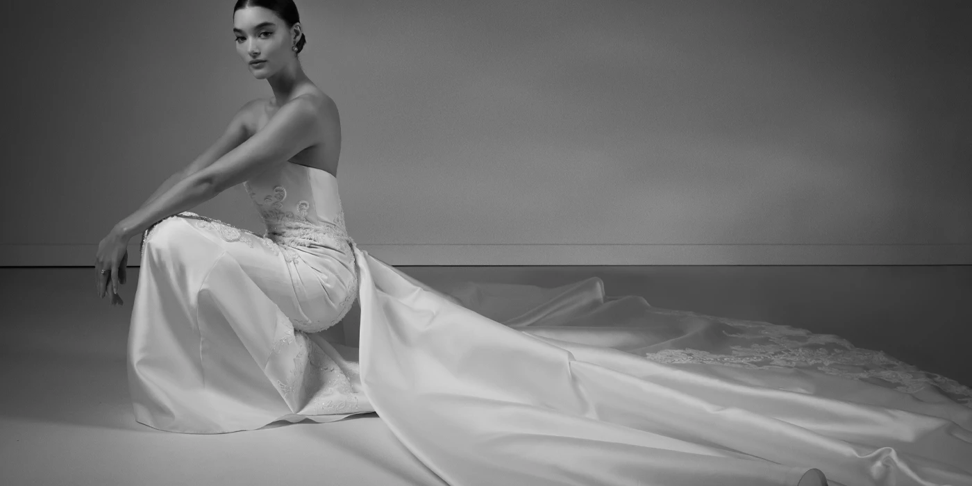 bride squatting in a satin wedding dress with long train