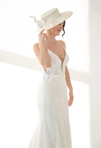 Bride wearing ML1305, a 3D lace wedding gown with a v-neck and a statement hat
