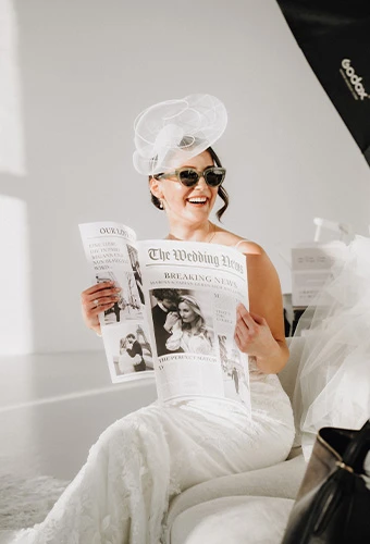 Bride wearing ML1305, a 3D lace wedding dress with v-neck and beading, featuring a statement hat and sunglasses