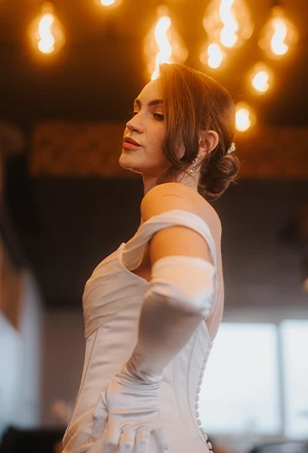 Bride wearing ML1806, a strapless satin column wedding dress with sweetheart neckline, paired with elegant gloves