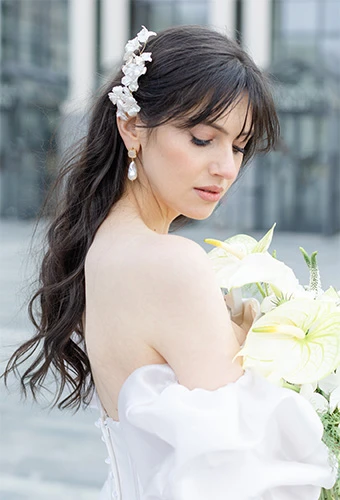 Bride wearing Stella York 7940, an elegant organza ballgown with puff sleeves, featuring a hair clip