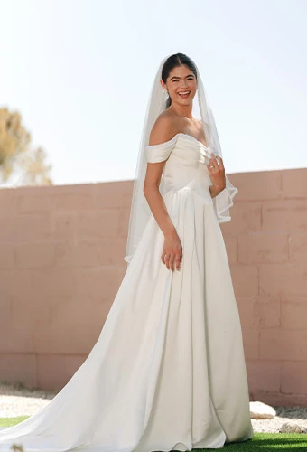 Bride wearing SY8236, a satin wedding dress with a-line silhouette and pearl-accented neckline, paired with a veil