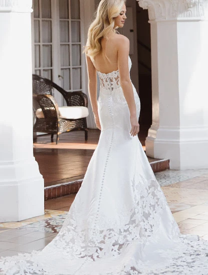 bride posing in lace mermaid wedding dress with sheer back