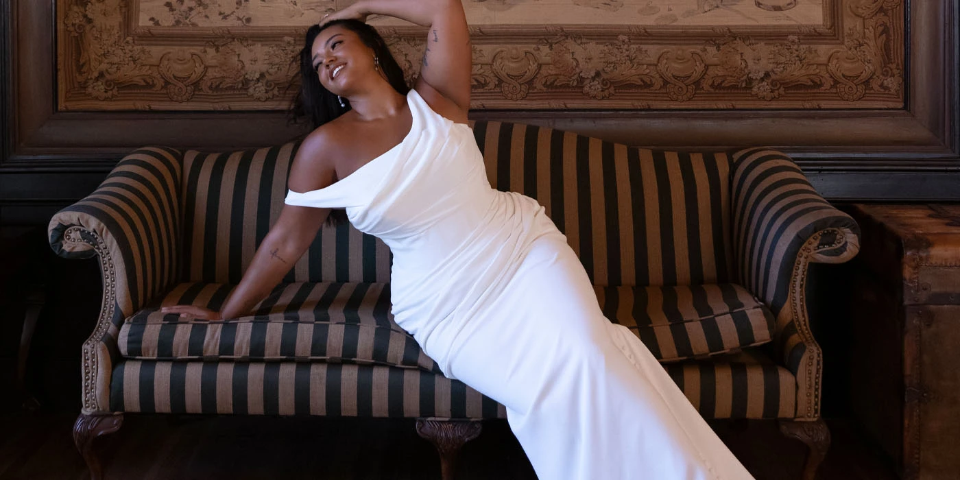 plus size bride posing in a simple sheath wedding dress