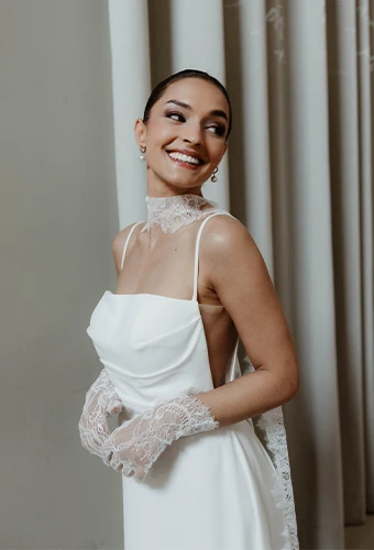 Bride wearing AWW jules, a spaghetti strap column wedding dress with side cutouts, paired with editorial gloves