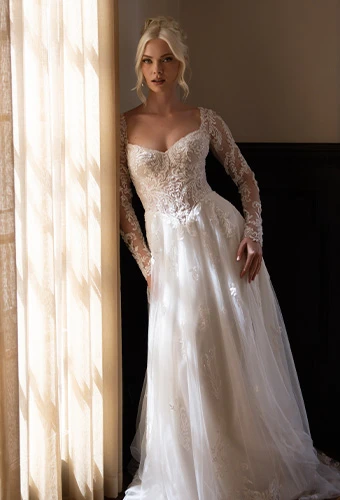 Bride wearing Essense of Australia style D4577, an a-line wedding dress with sweetheart neckline and long lace sleeves