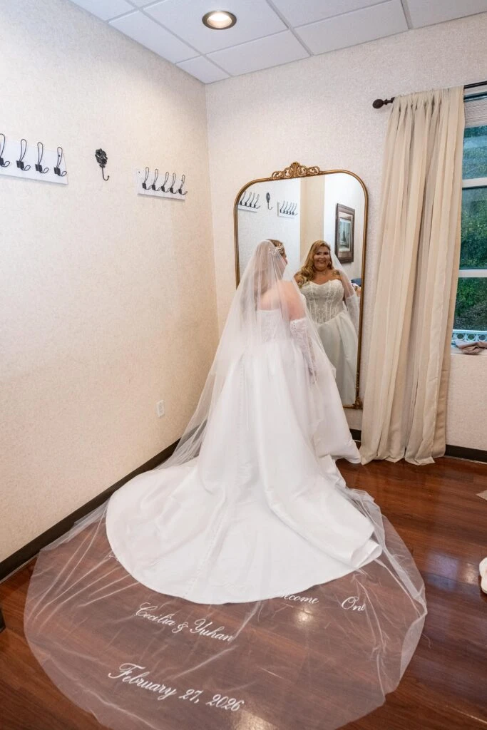 True bride Cecillia posing in her wedding gown in the mirror