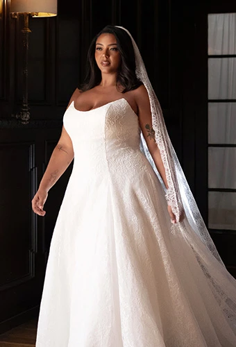 Plus size bride wearing strapless lace wedding dress with scoop neckline