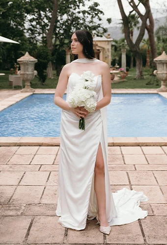 Bride posing in simpe wedding gown with bouquet