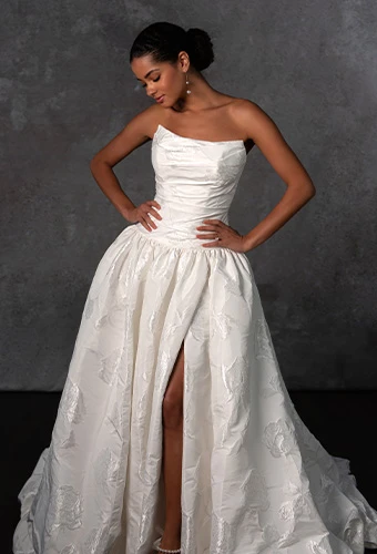 Bride wearing strapless ballgown wedding dress with high leg slit and bubble hem