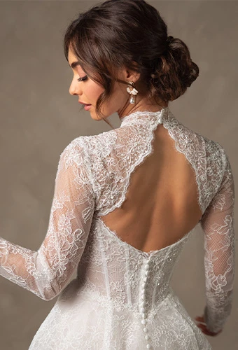 Bride wearing lace ballgown wedding dress with high neckline and long sleeves