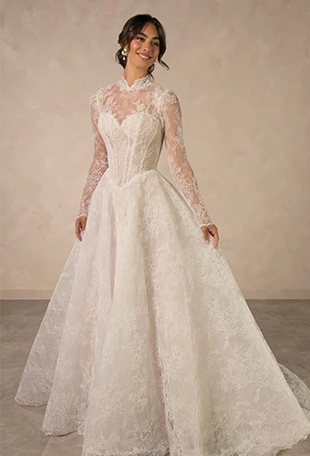 Bride wearing lace ballgown wedding dress with high neckline, long sleeves, and sweetheart neckline