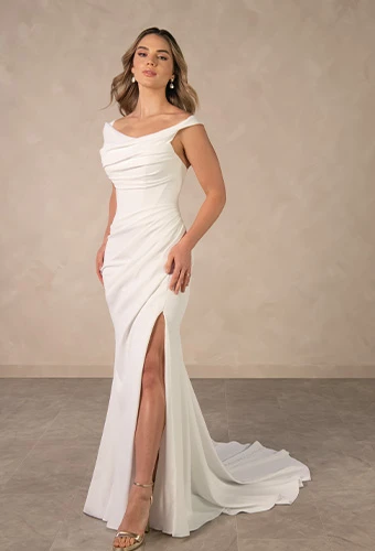 Bride wearing simple fit and flare wedding gown with high leg slit and off the shoulder straps