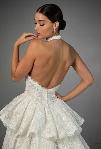 Bride wearing lace halter wedding dress with high neckline and peplum waist