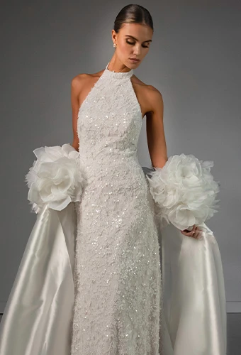 Bride wearing sparkling lace wedding gown with high neckline and beading
