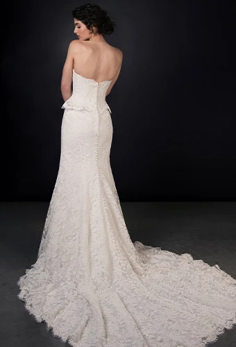 Bride wearing lace strapless fit-and-flare wedding dress with peplum waist
