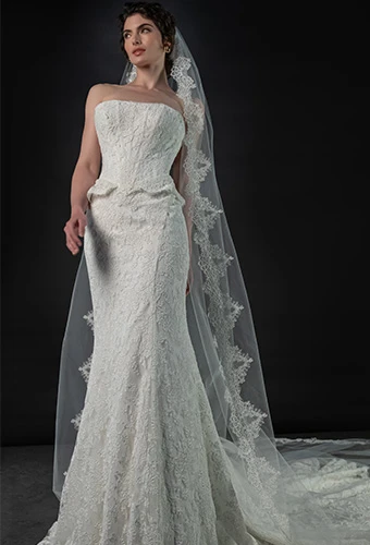 Bride wearing lace strapless fit-and-flare wedding dress with peplum waist